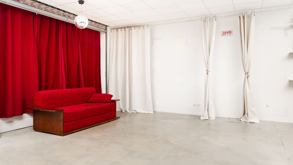 Décors et ambiances studio à Toulouse : le Petit Plateau du Loft, rideau de velours rouge, canapé et rideaux crème