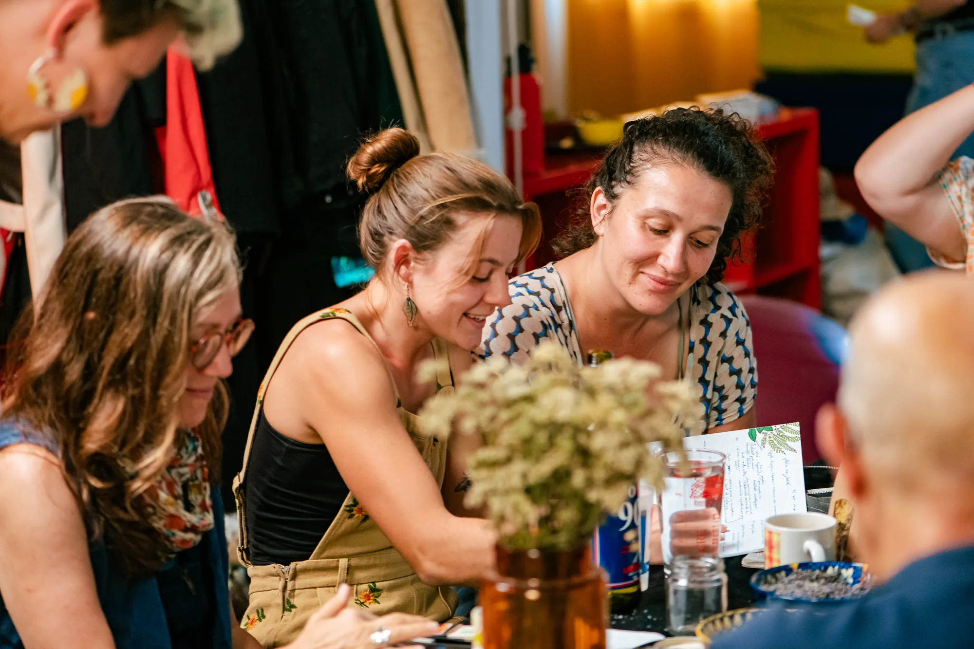 Participantes souriantes autour de la table pendant l'atelier d'herboristerie au Loft