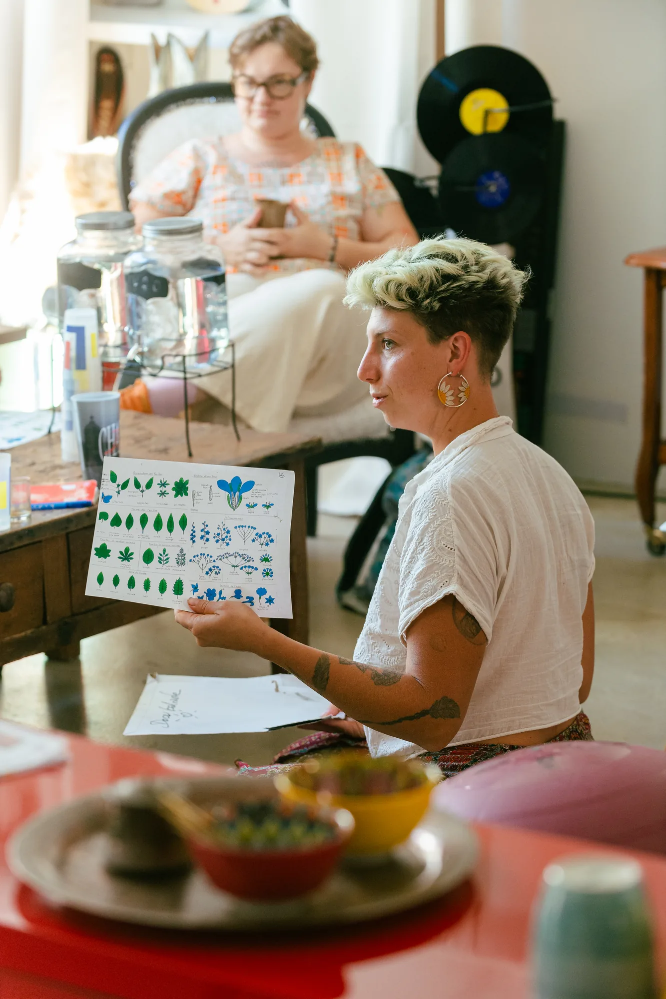 Judith présente une planche de plantes à un petit groupe pendant l'atelier d'herboristerie au Loft à Toulouse
