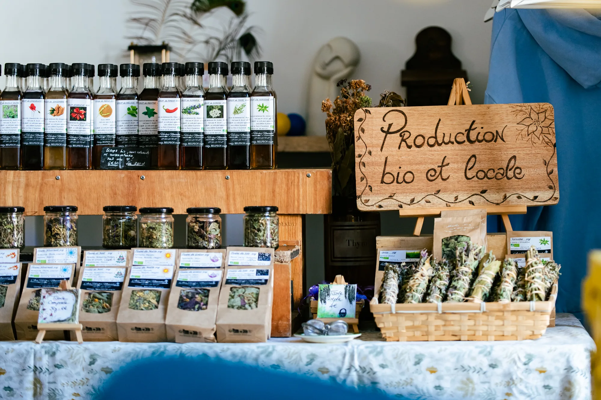 Stand Aux Herbes Nomades au Loft : sirops, tisanes et plantes séchées, panneau production bio et locale